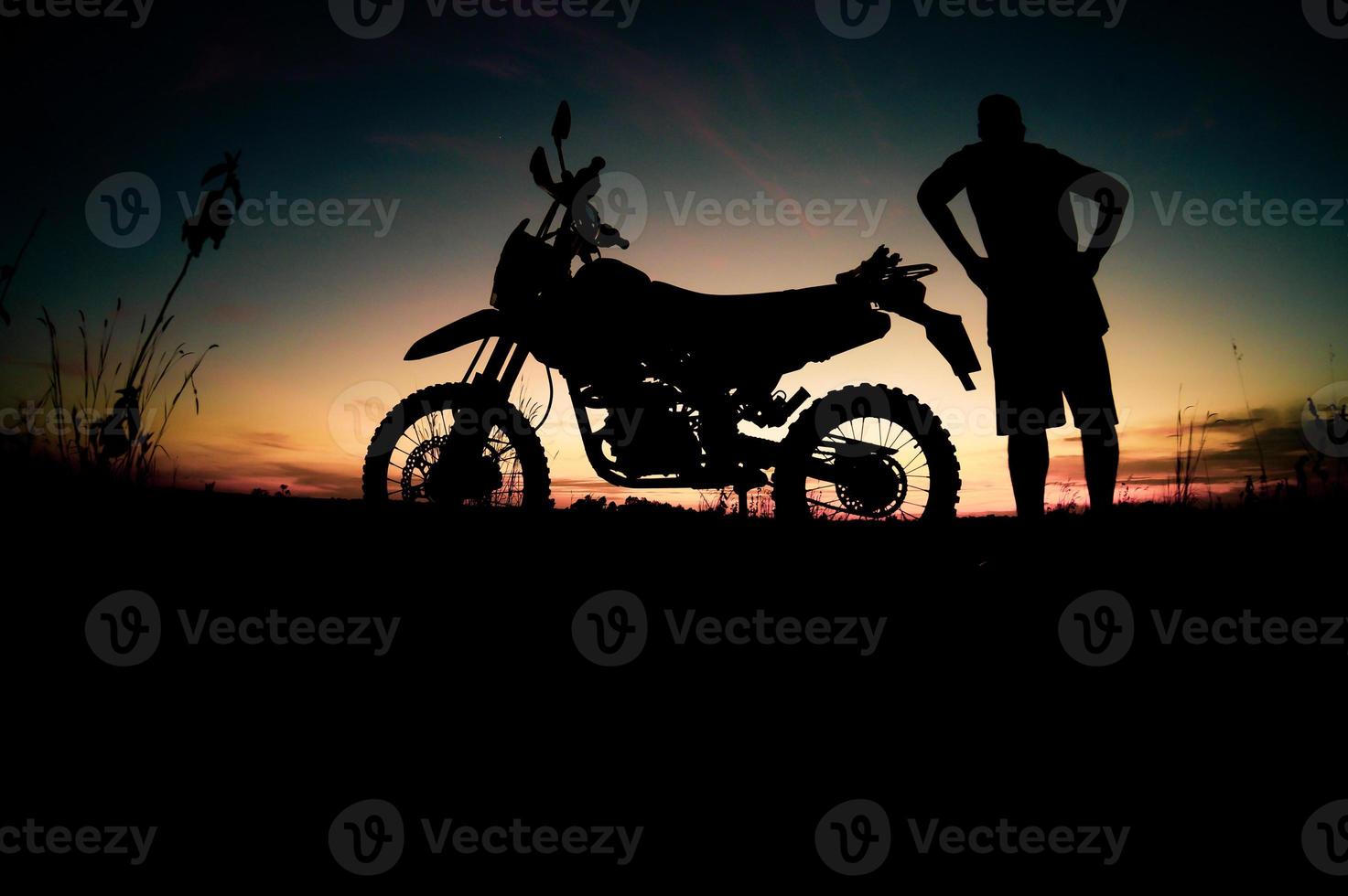 Herren-Silhouetten und Touren-Motocross-Bikes. Park zum Entspannen in den Bergen am Abend. abenteuerreise- und freizeitkonzept foto