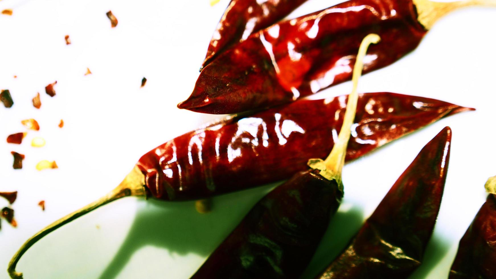 rote Chilischoten, Chiliflocken vor einem weißen Hintergrund foto
