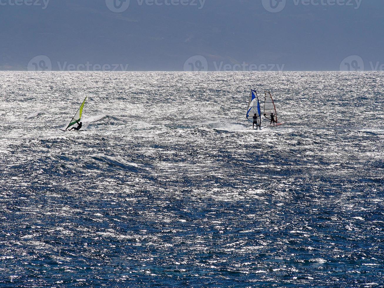 blaues wasser drei windsurfer strahlende sonne foto