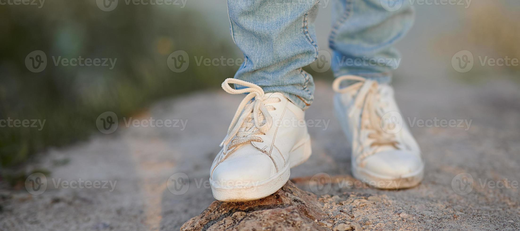 Frauenbeine in Jeans und Turnschuhen. ein Bein in einer Unschärfe. foto