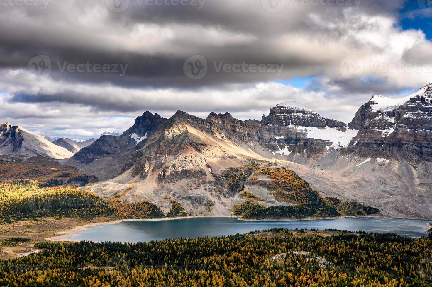 felsige berge mit sonnenlicht und see auf düsterem assiniboine provincial park foto