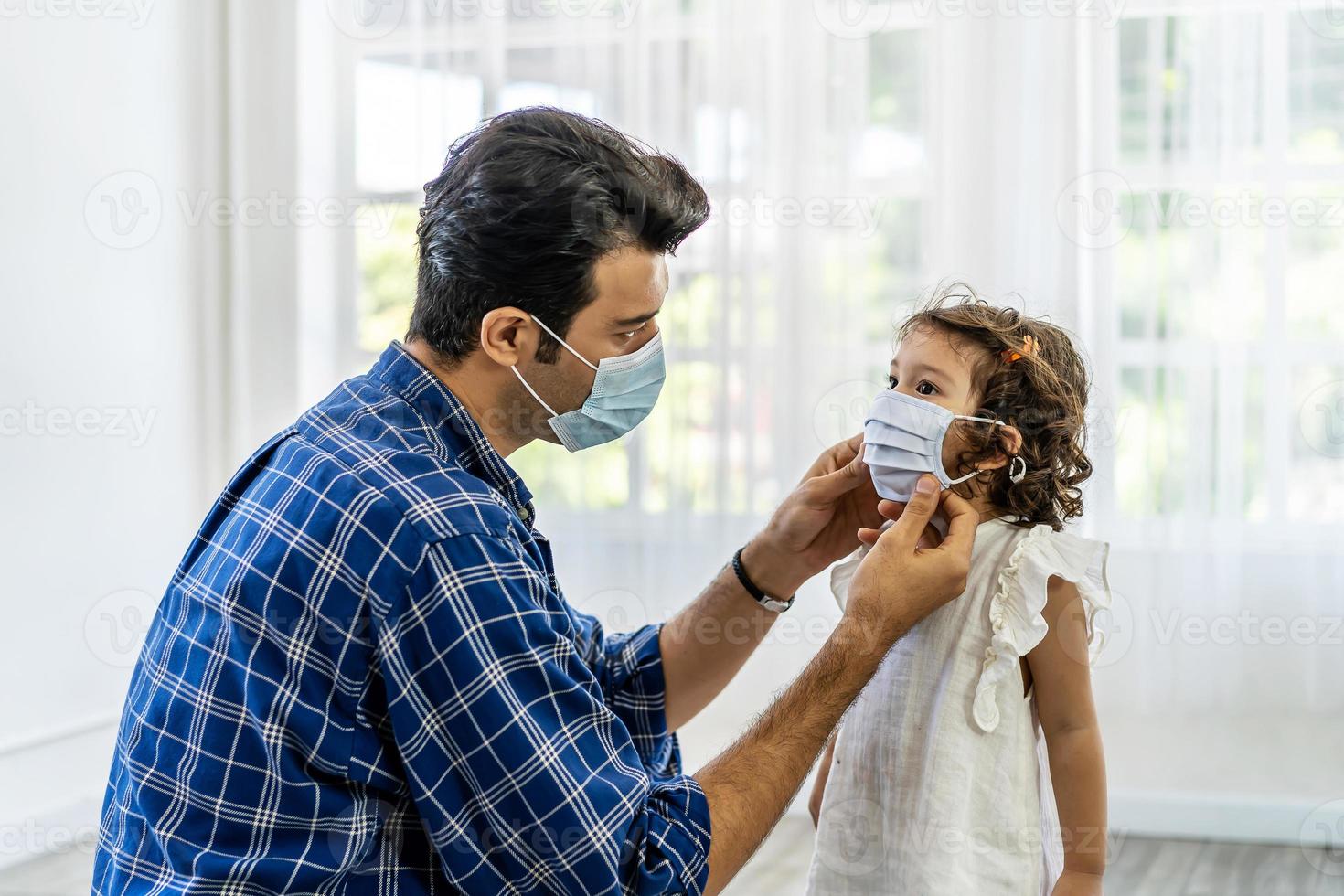 vater trägt die gesichtsmaske für die kleine tochter, beide tragen gesichtsmasken, um auf ihre gesundheit zu vertrauen. schützen sie sich vor der gefährlichen ausbreitung des coronavirus covid-19 foto