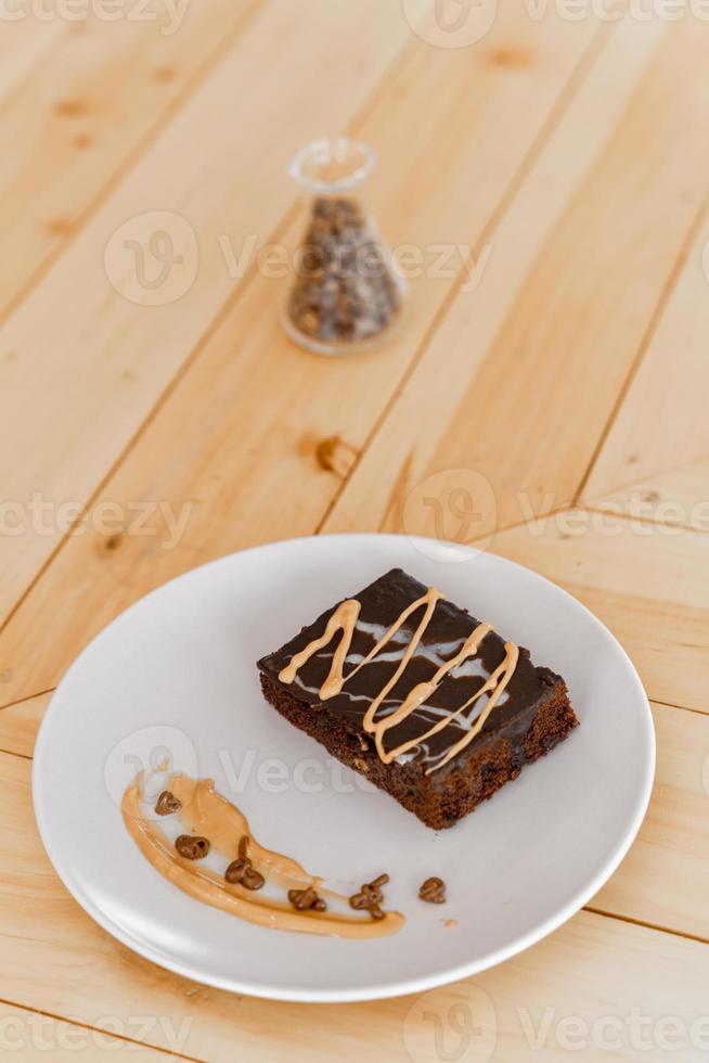 Tasse heißen Cappuccino-Kaffee auf dem Tisch mit Fudge-Kuchen foto