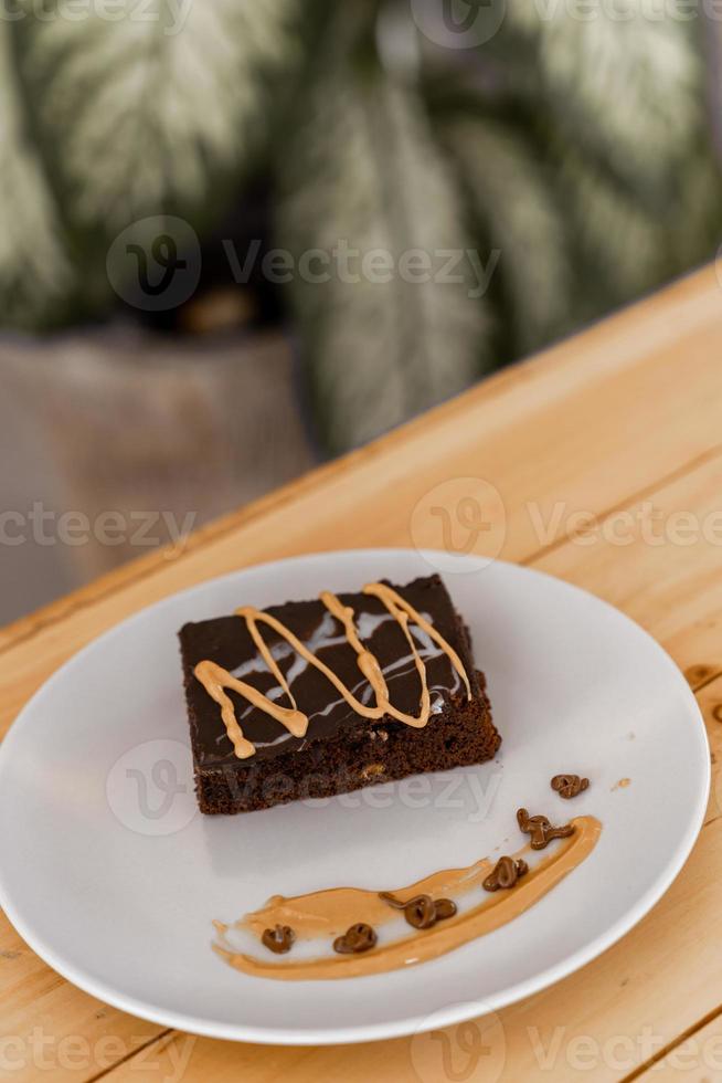 Tasse heißen Cappuccino-Kaffee auf dem Tisch mit Fudge-Kuchen foto