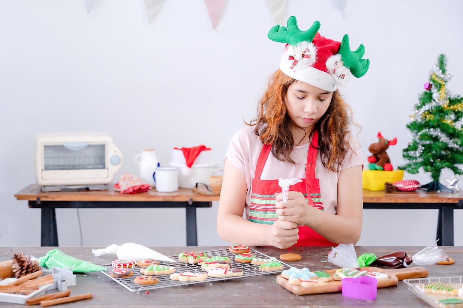 europäische mädchen verwenden werkzeuge und zutaten, um lebkuchen zu weihnachten und neujahr zu backen foto