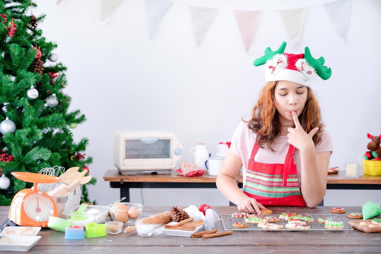 ein junges europäisches mädchen testet den lebkuchen, den sie zu weihnachten und neujahr macht foto