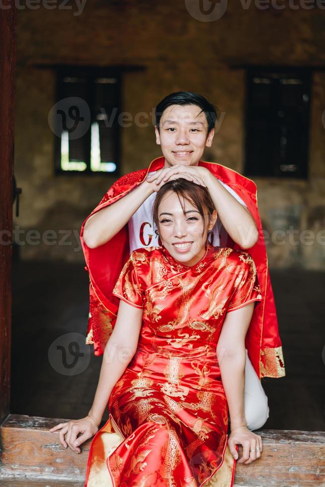 glückliches junges asiatisches paar in chinesischen traditionellen kleidern foto