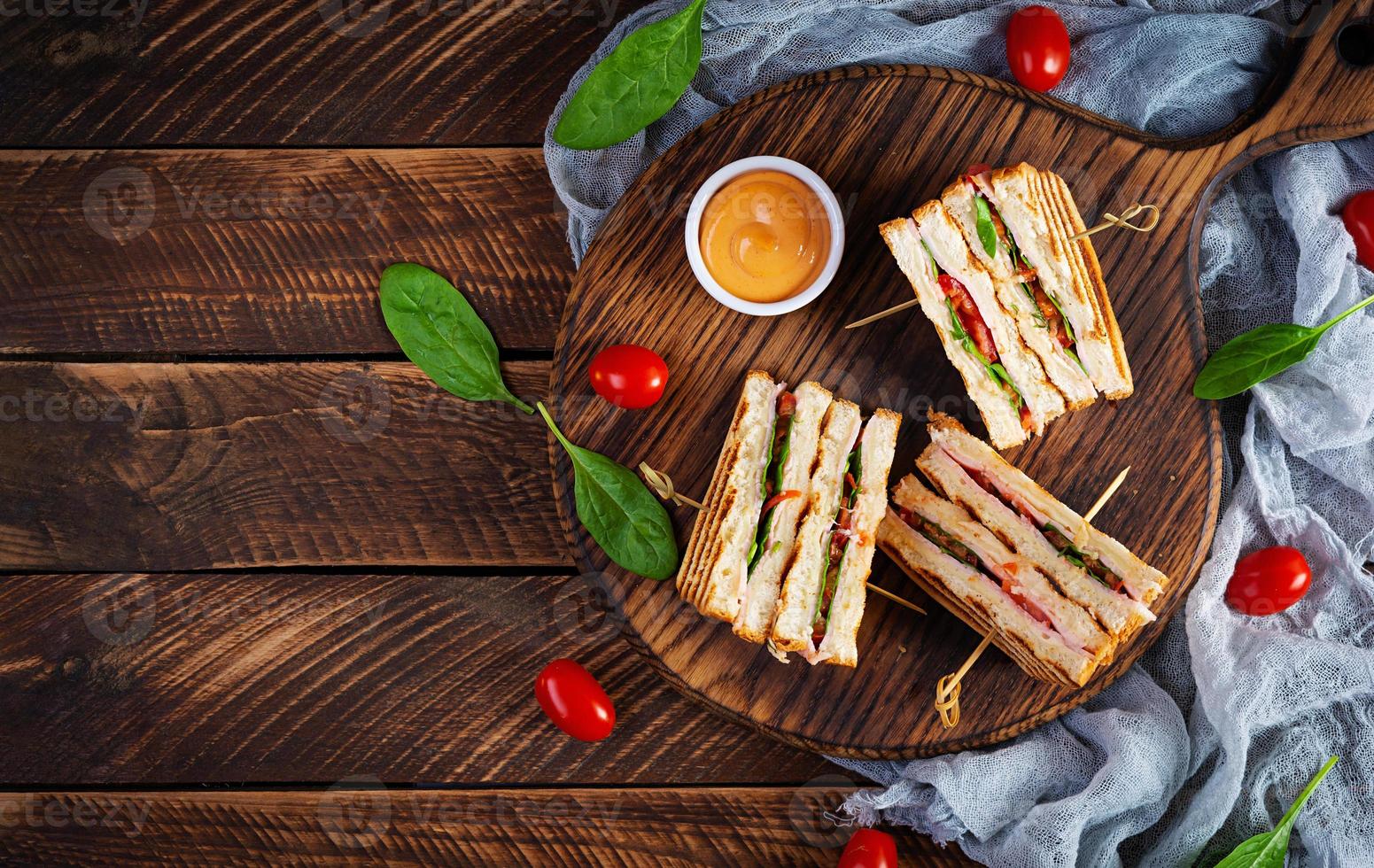 Club-Sandwich mit Schinken, Tomate, Käse und Spinat. gegrillte panini. Ansicht von oben foto