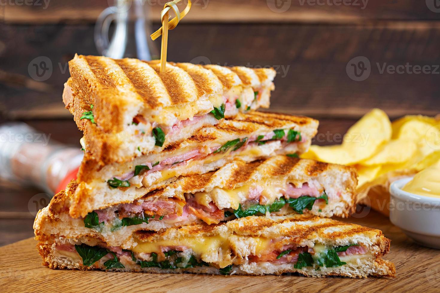 Club-Sandwich mit Schinken, Käse, Tomate, Salat und Pommes foto