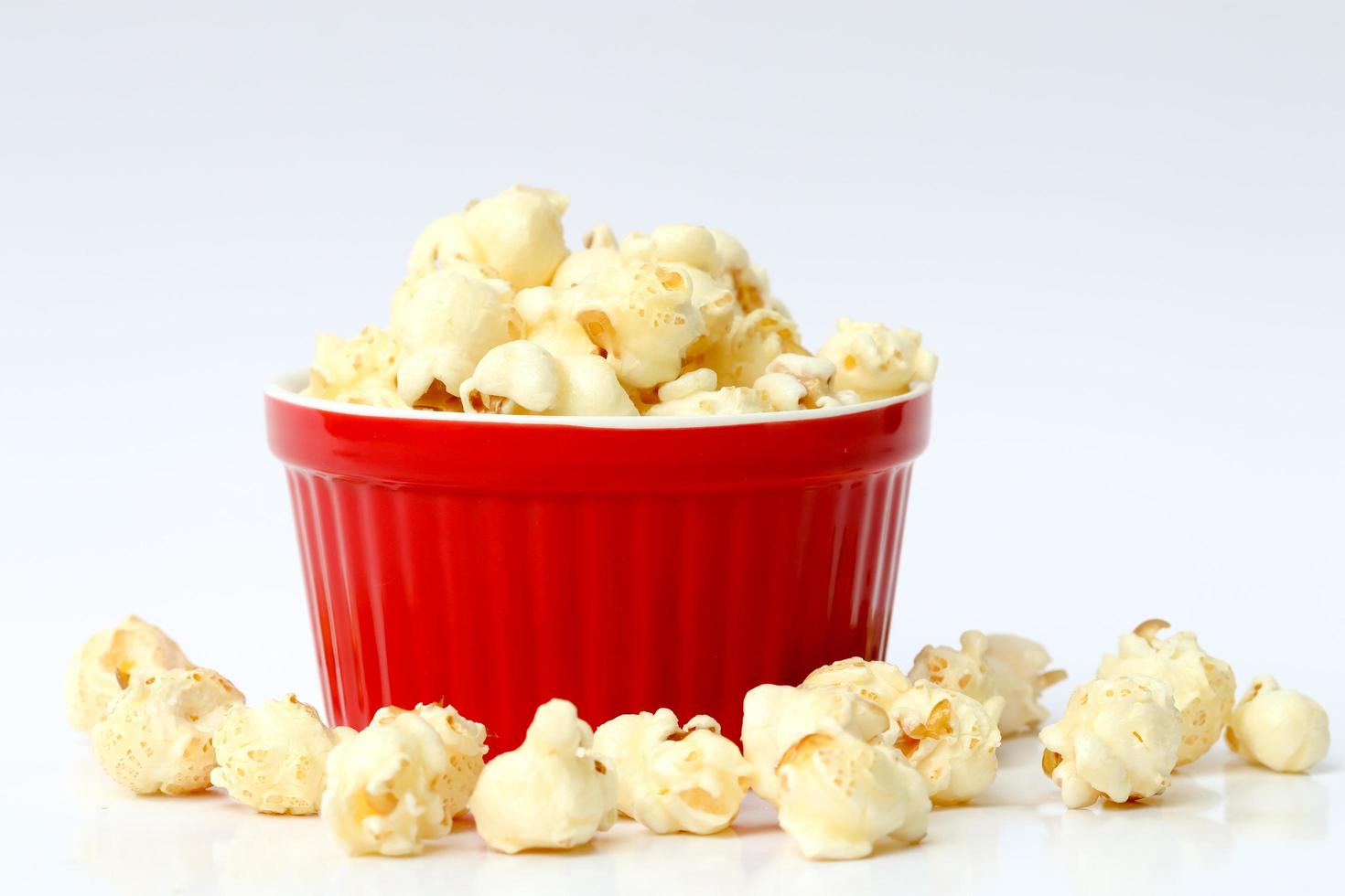 Popcorn auf roter Schüssel mit weißem Hintergrund. foto
