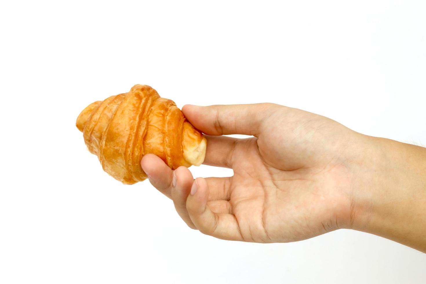 Hand und Mini-Croissant mit weißem Hintergrund. foto