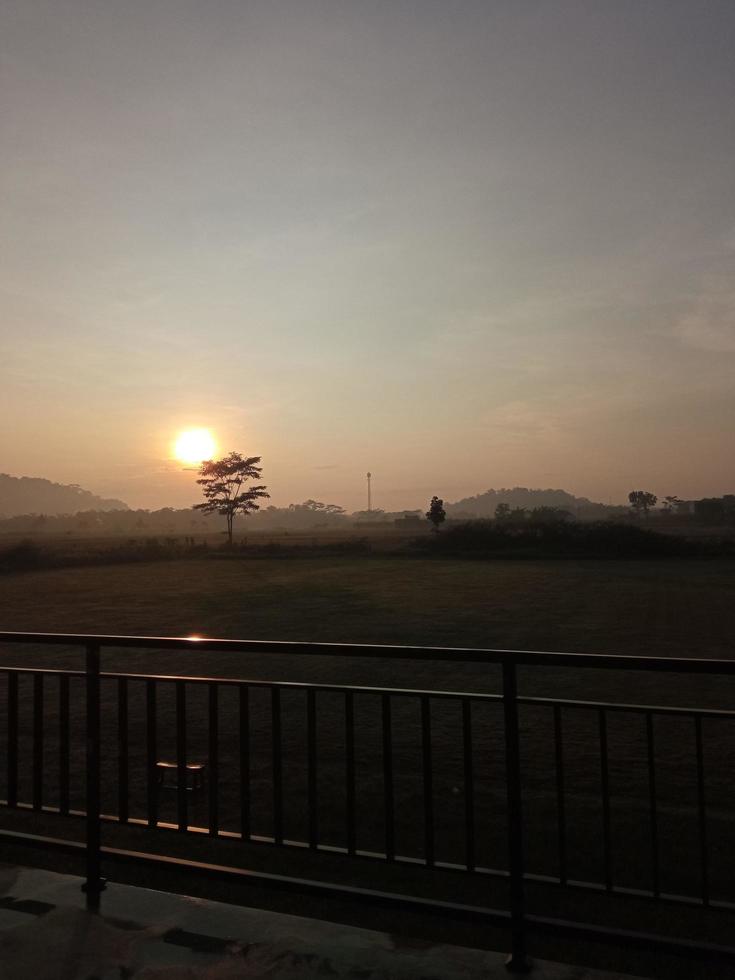 Sehen Sie die Atmosphäre des Morgens, wenn die Sonne gerade über den Feldständen aufgeht foto