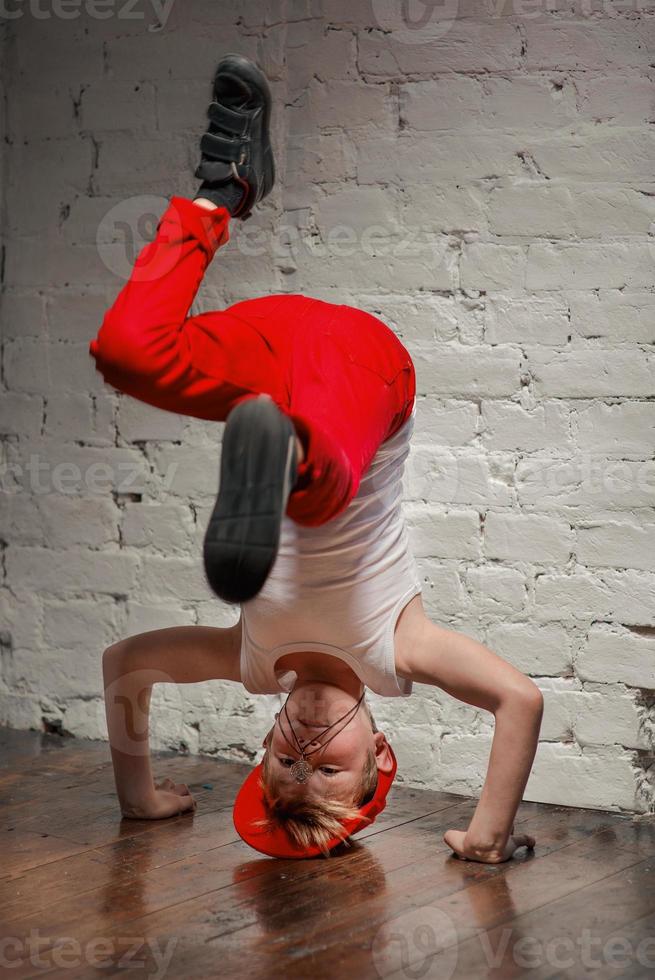 Porträt eines coolen jungen Hip-Hop-Jungen mit rotem Hut und roter Hose und weißem Hemd auf dem Dachboden foto