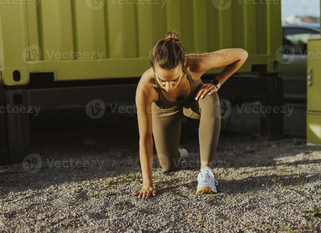 junge frau in sportbekleidung, die im städtischen umfeld trainiert foto