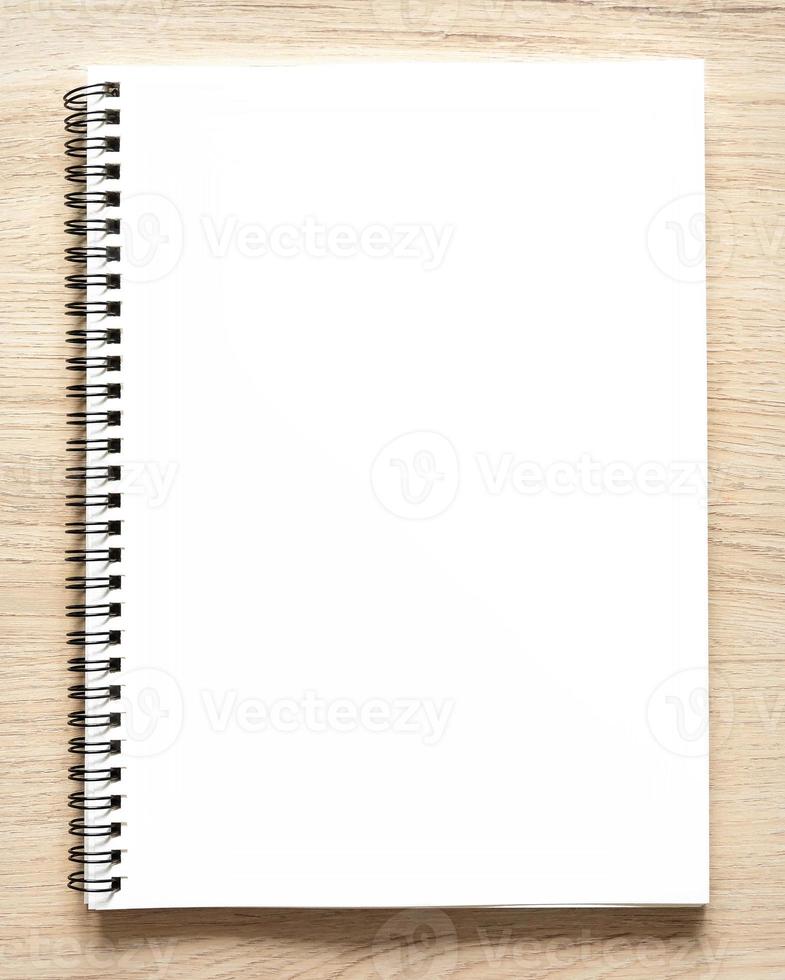 leere spiralgebundene notepad mockup-vorlage mit kraftpapierabdeckung, isoliert auf holzhintergrund. foto