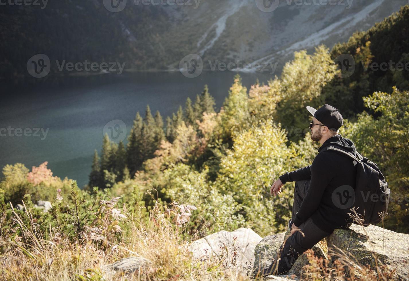 Mann Tourist entspannt sich auf der Spitze eines Hügels foto