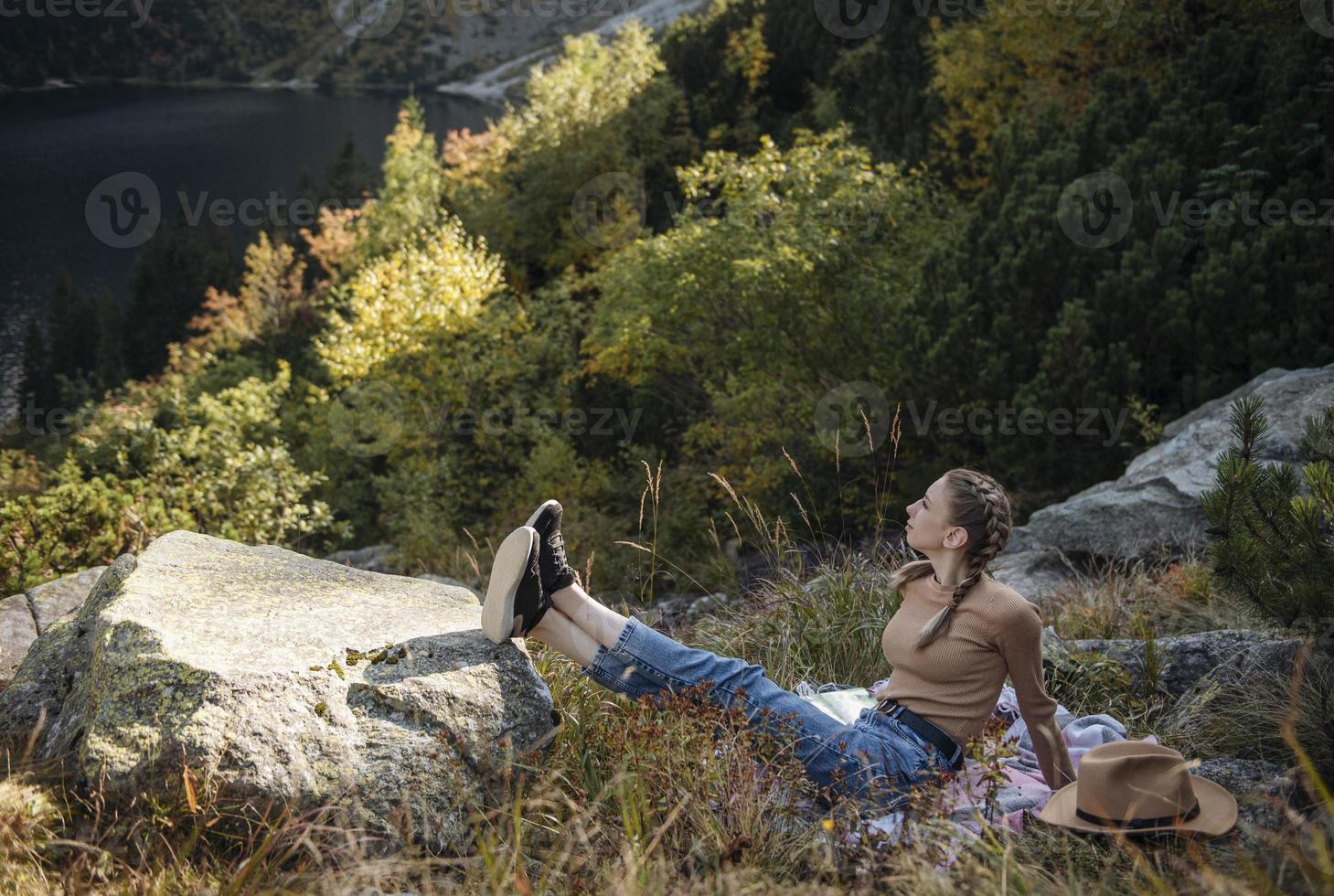 junge frau auf einer wanderung, die auf einem felsen sitzt foto