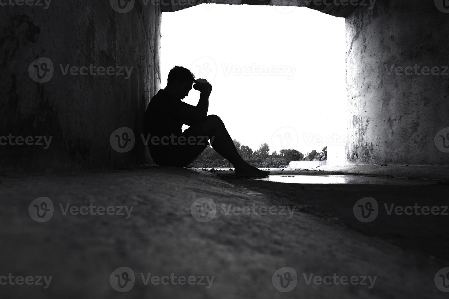 asien du mann sitzt allein. er sitzt unter einem großen tunnel. mann sehr traurig und deprimiert. traurig, allein, selbstmord. verzweiflung. sickness.photo Gesundheits- und Enttäuschungskonzept. foto