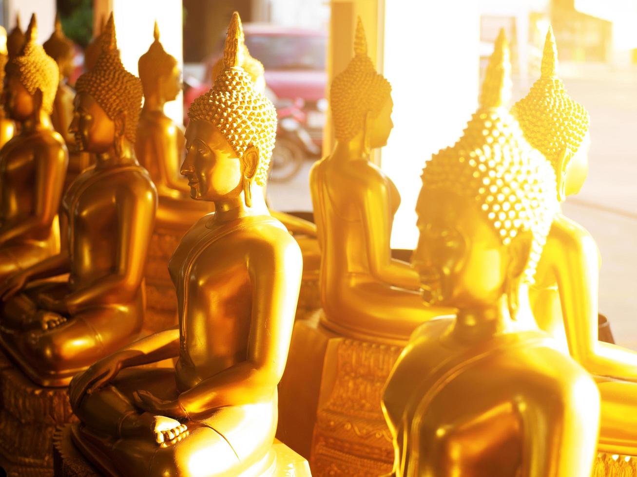 schöne Buddha-Statue und goldenes Licht foto