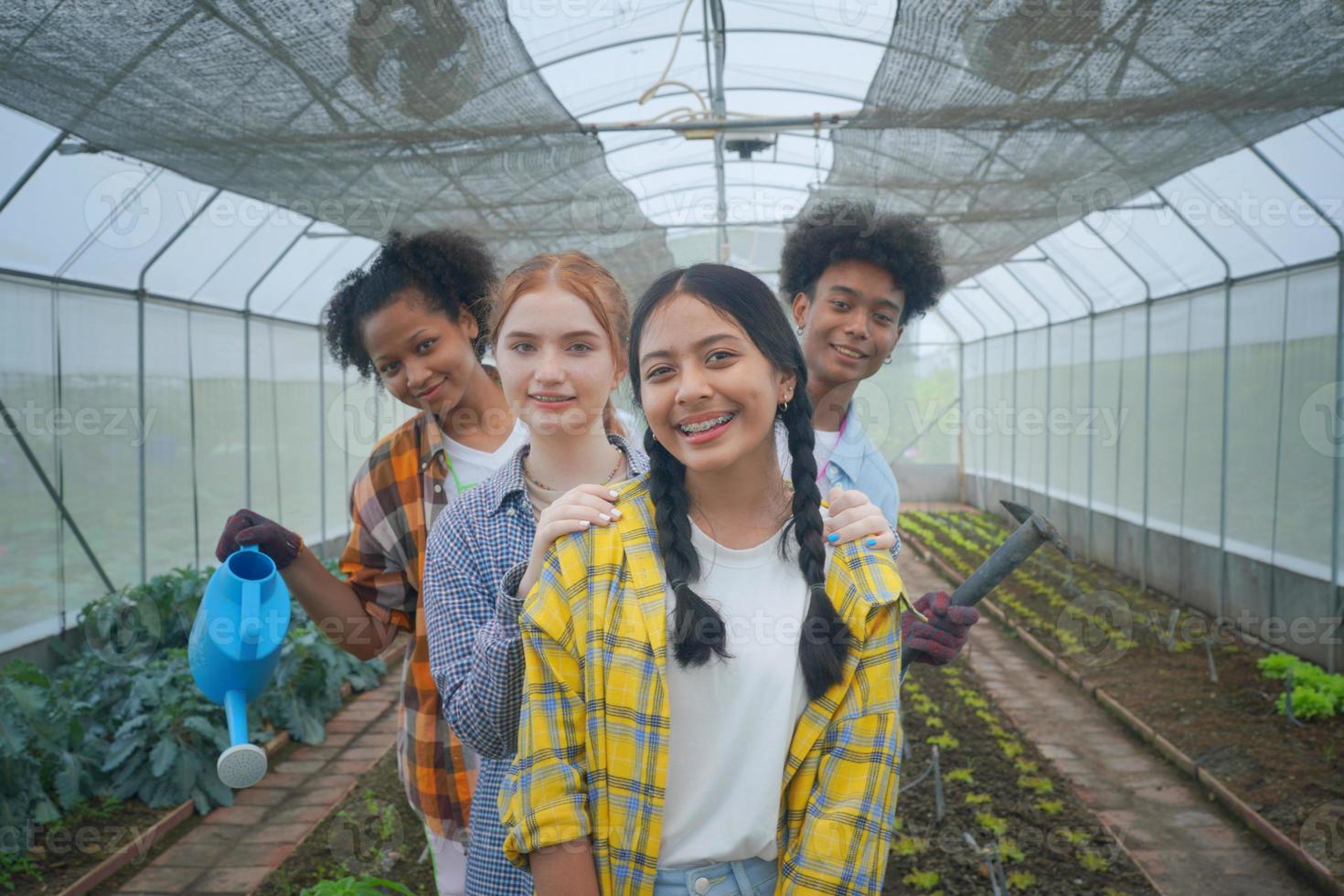 Eine junge, vielfältige Gruppe, die Spaß hat und Emotionen im Gewächshaus der Plantage Organic Farm genießt. foto