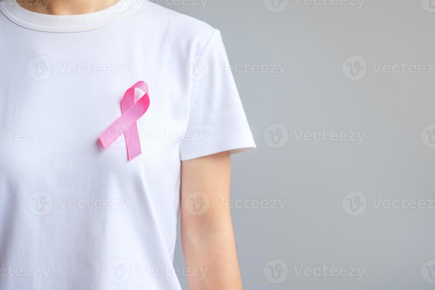 oktober brustkrebsbewusstseinsmonat, ältere frau in weißem t-shirt mit rosa band zur unterstützung lebender und kranker menschen. internationales frauen-, mutter- und weltkrebstagskonzept foto