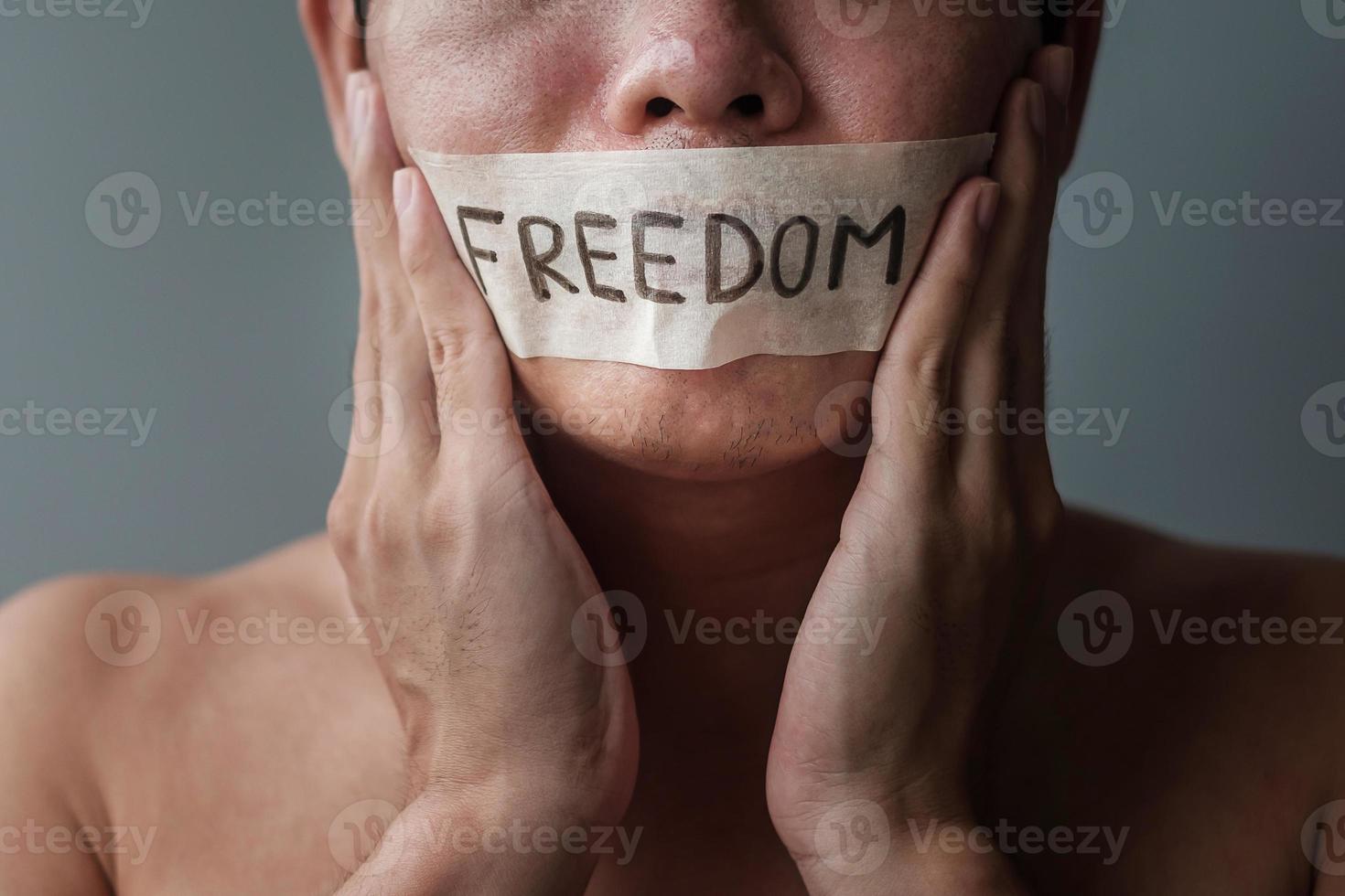 Mann mit Mund in Klebeband mit Freiheitsbotschaft versiegelt. Meinungsfreiheit, Pressefreiheit, Menschenrechte, Protestdiktatur, Demokratie, Freiheit, Gleichheit und Brüderlichkeitskonzepte foto