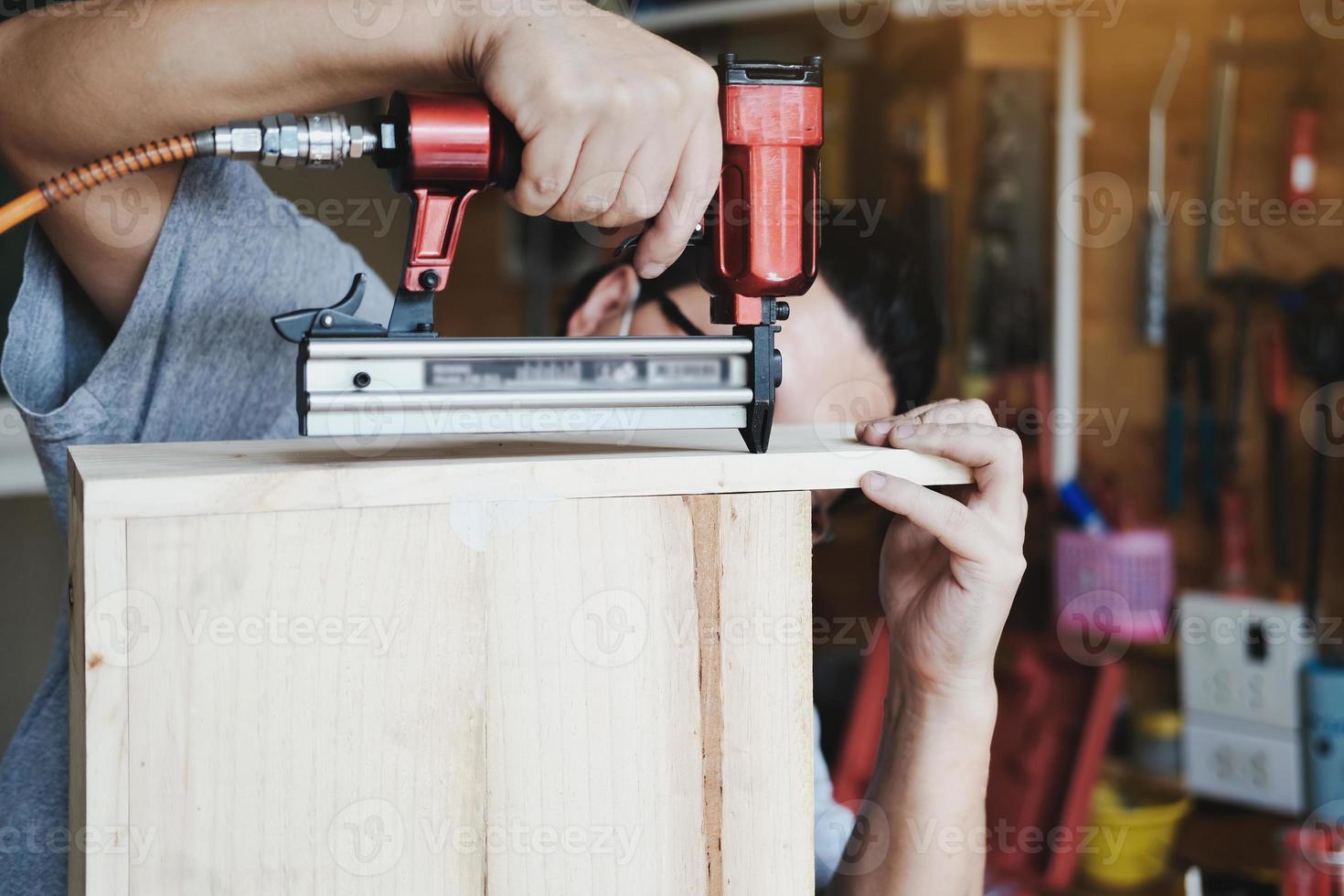 Unternehmer Holzarbeiten, die einen Tacker halten, um die Holzstücke nach Kundenwunsch zusammenzubauen. foto