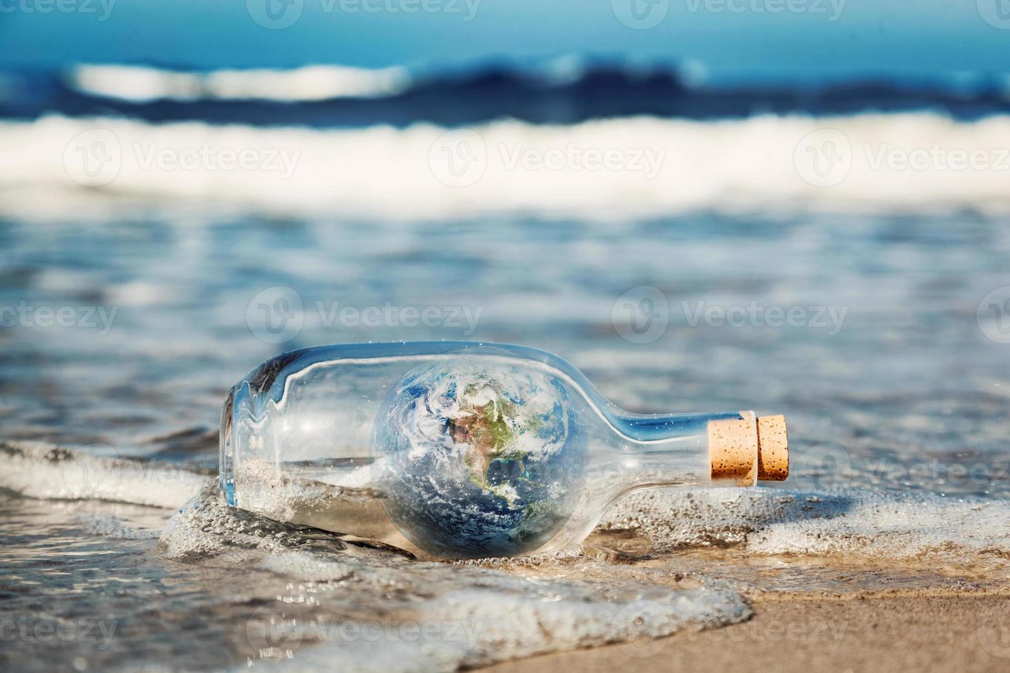 erde in der flasche kommt mit wellen vom ozean. umwelt, saubere weltbotschaft foto