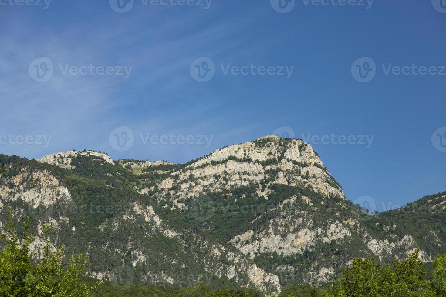 eine wunderschöne Morgenlandschaft einer Bergkette mit einem markanten Gipfel gegen den blauen Himmel. Platz kopieren. foto