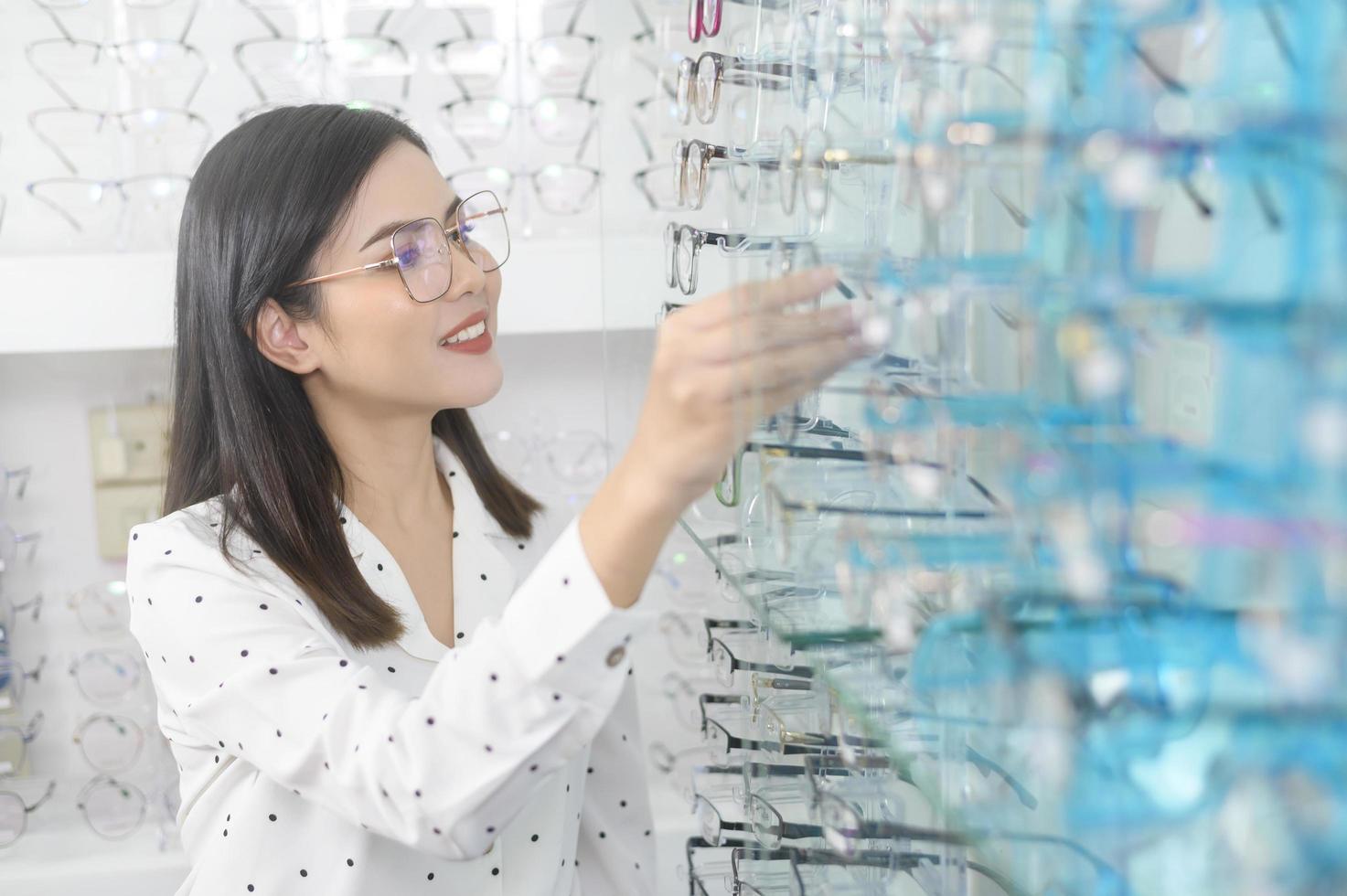 junge Kundin, die sich im optischen Zentrum für eine Brille entscheidet, Augenpflegekonzept. foto