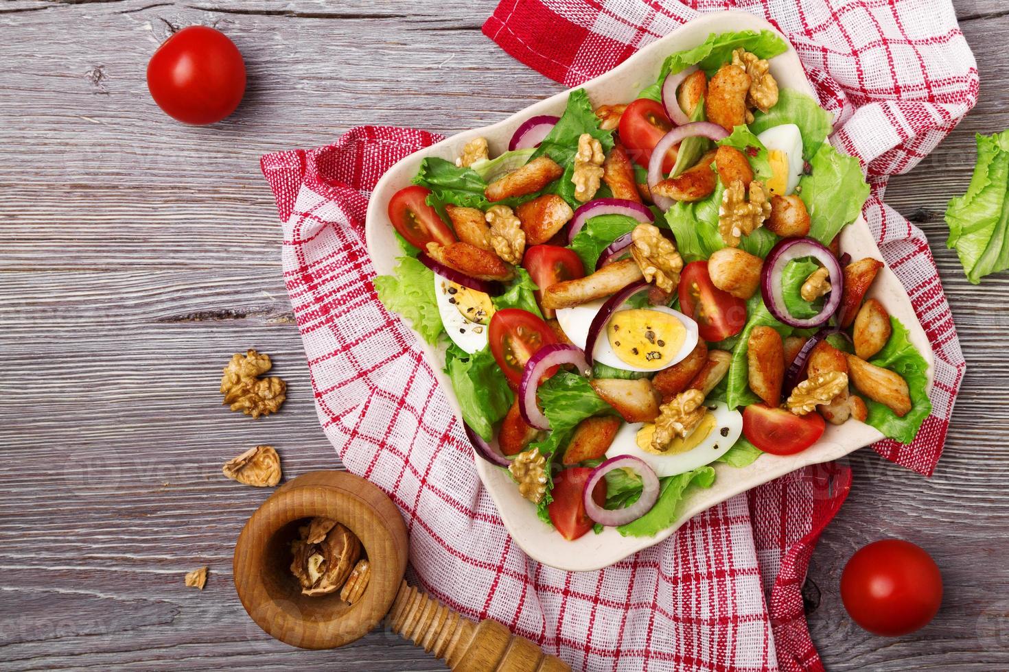 leckerer Salat mit Huhn, Nüssen, Ei und Gemüse. foto