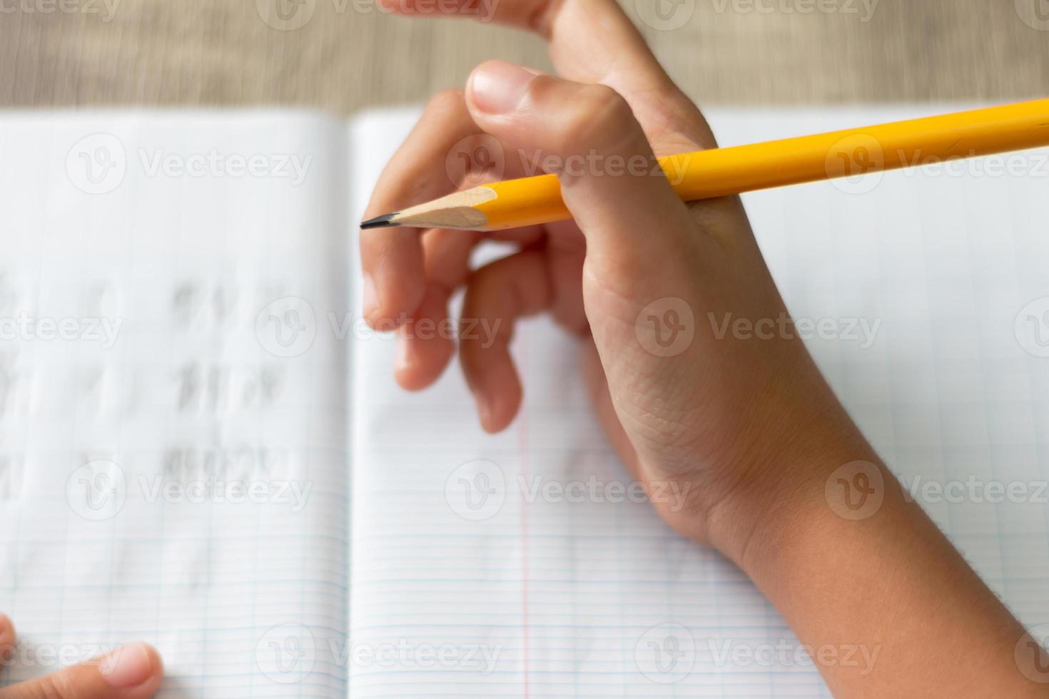 hand hält einen gelben bleistift mit hohem winkel foto