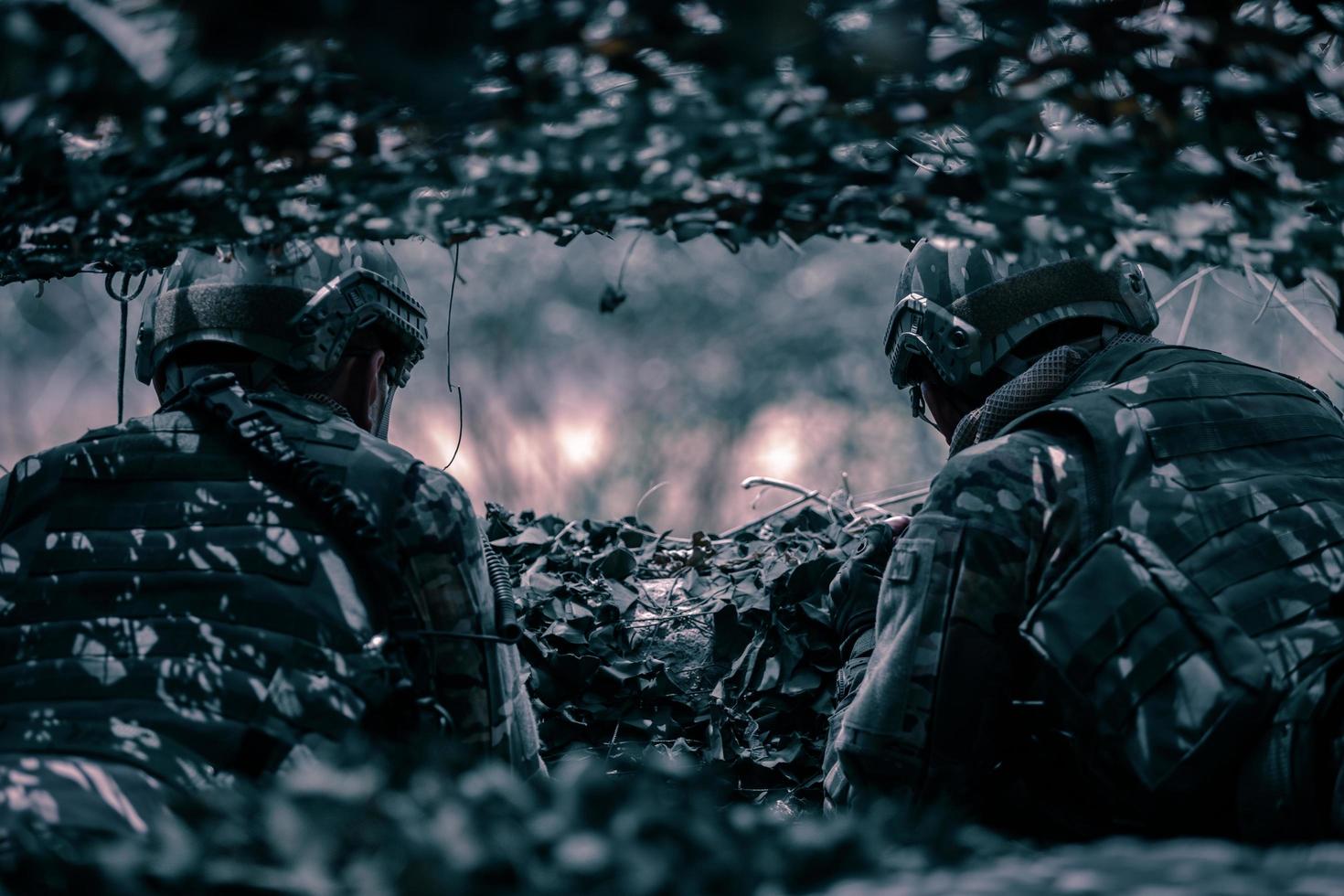Rückansicht von Soldaten auf dem Schlachtfeld, Militärstützpunkt, Mission im Gange, nachts im Wald foto