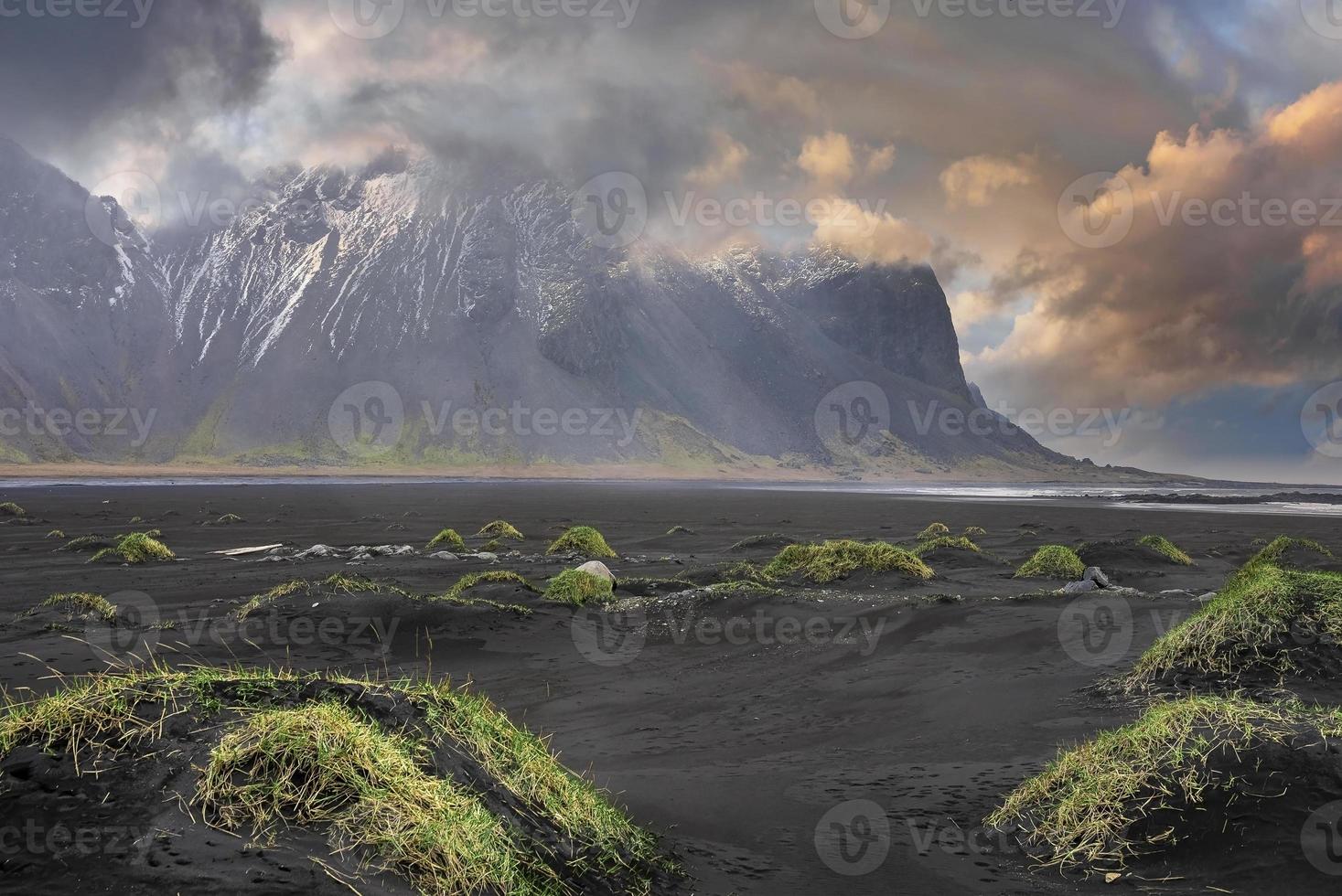 schönes gras am strand gegen stokksnes cape und vestrahorn berg bei sonnenuntergang foto