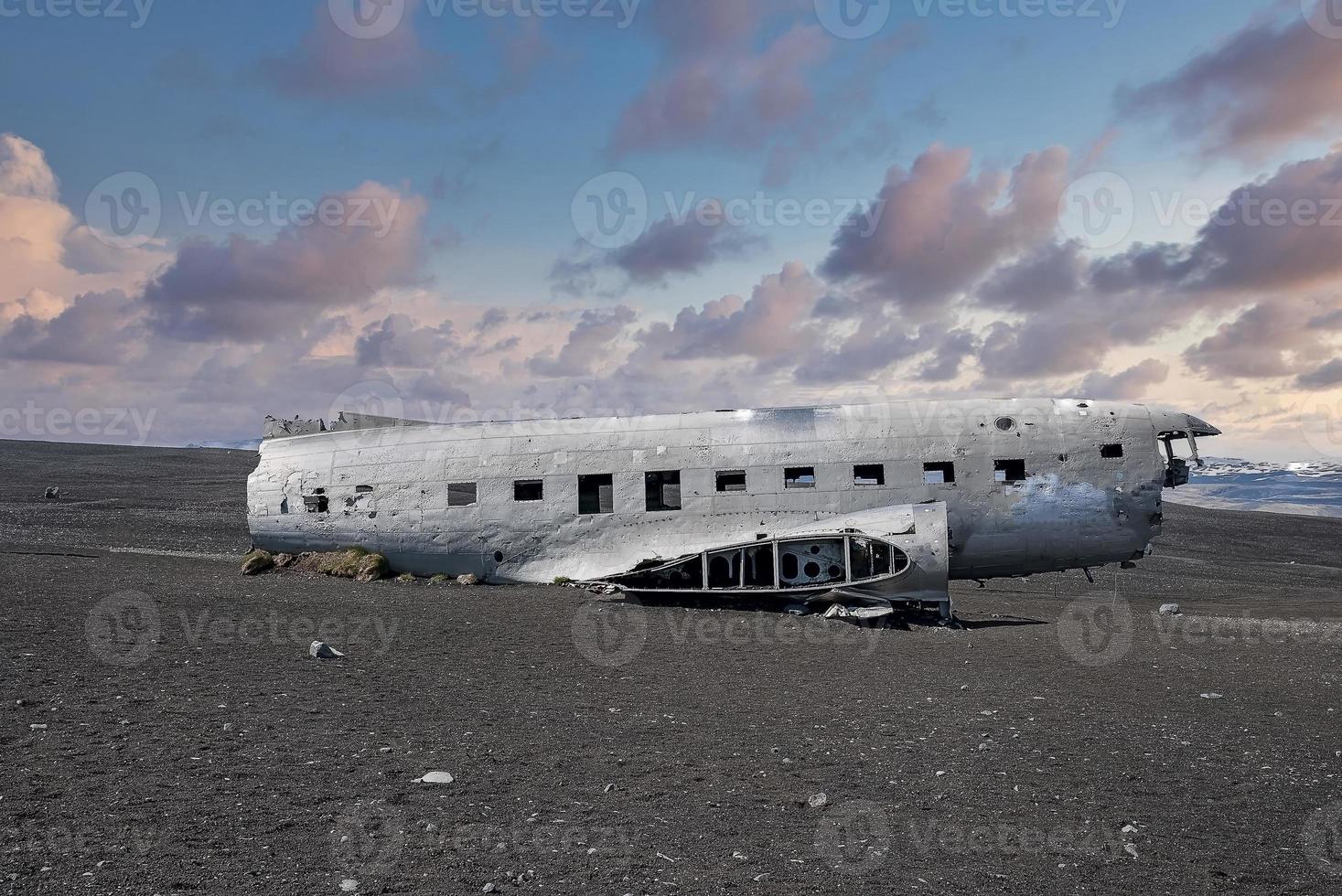 Verlassenes beschädigtes Flugzeugwrack am schwarzen Sandstrand in Solheimasandur bei Sonnenuntergang foto