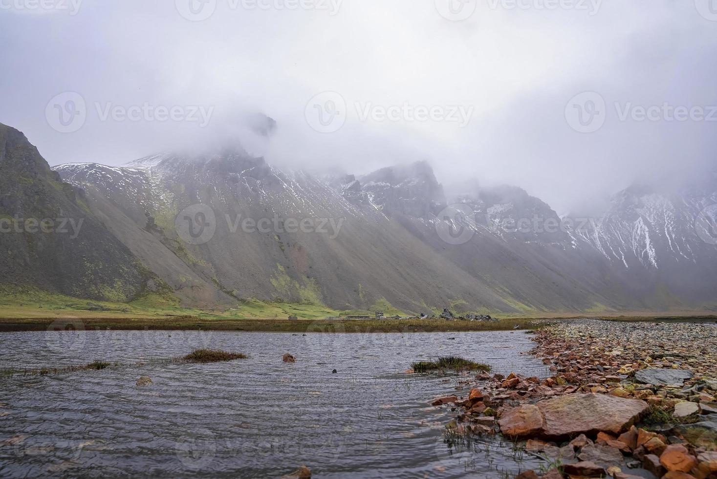 Nahaufnahme des Baches, der inmitten einer Wiese gegen den Berg Vestrahorn fließt foto