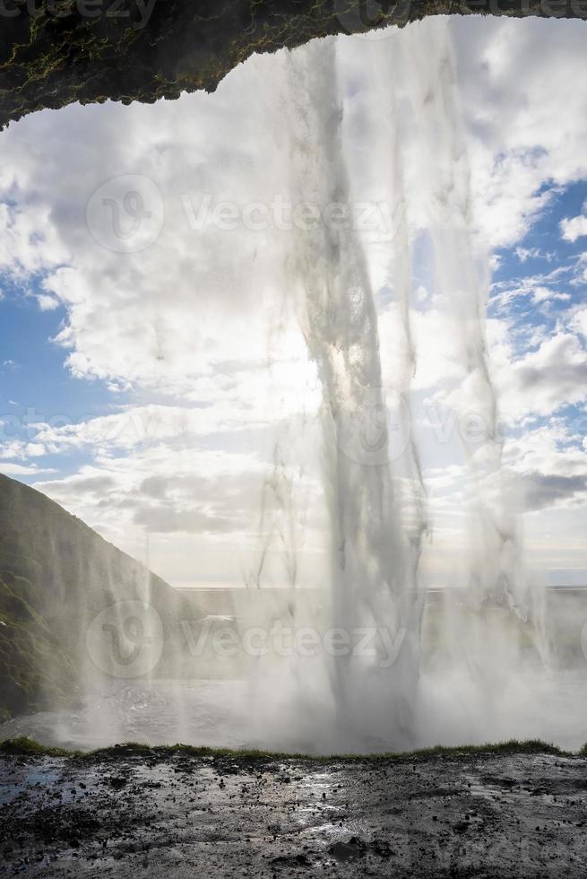 majestätischer seljalandsfoss mit nebel, der vom berg gegen blauen himmel fließt foto