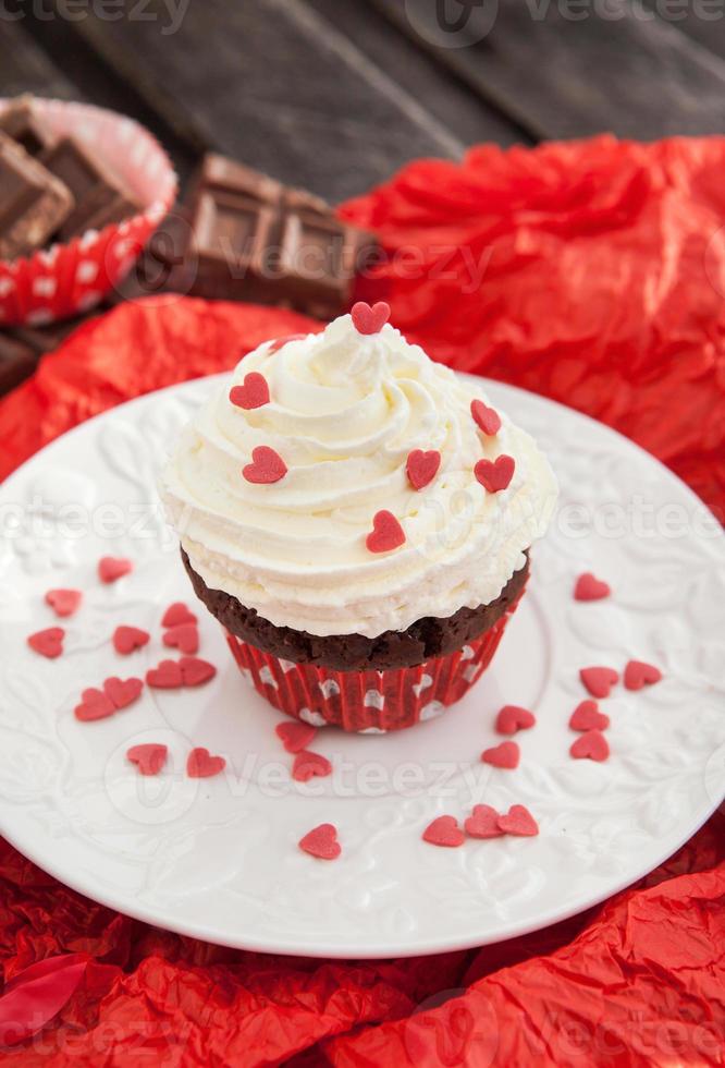 Schokoladen Cupcake mit roten Herzen verziert foto