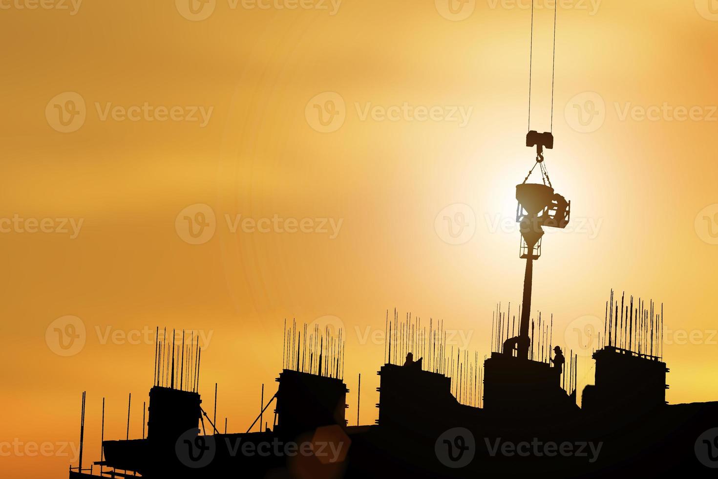 Architektensilhouette, die bei Sonnenuntergang an Baustellenarbeitern arbeitet, Industriekonzept. foto