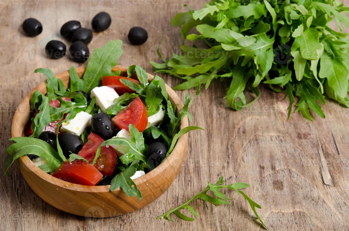 Griechischer Salat in einer hölzernen Salatschüssel auf dem Tisch foto