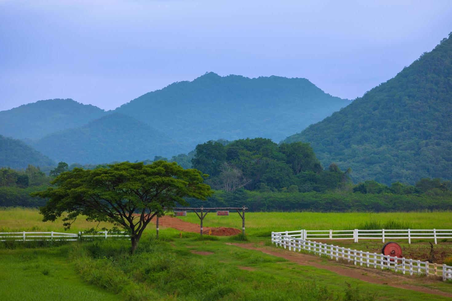 Die grüne Ranch hinter dem Berg hat einen strahlend blauen Himmel. foto