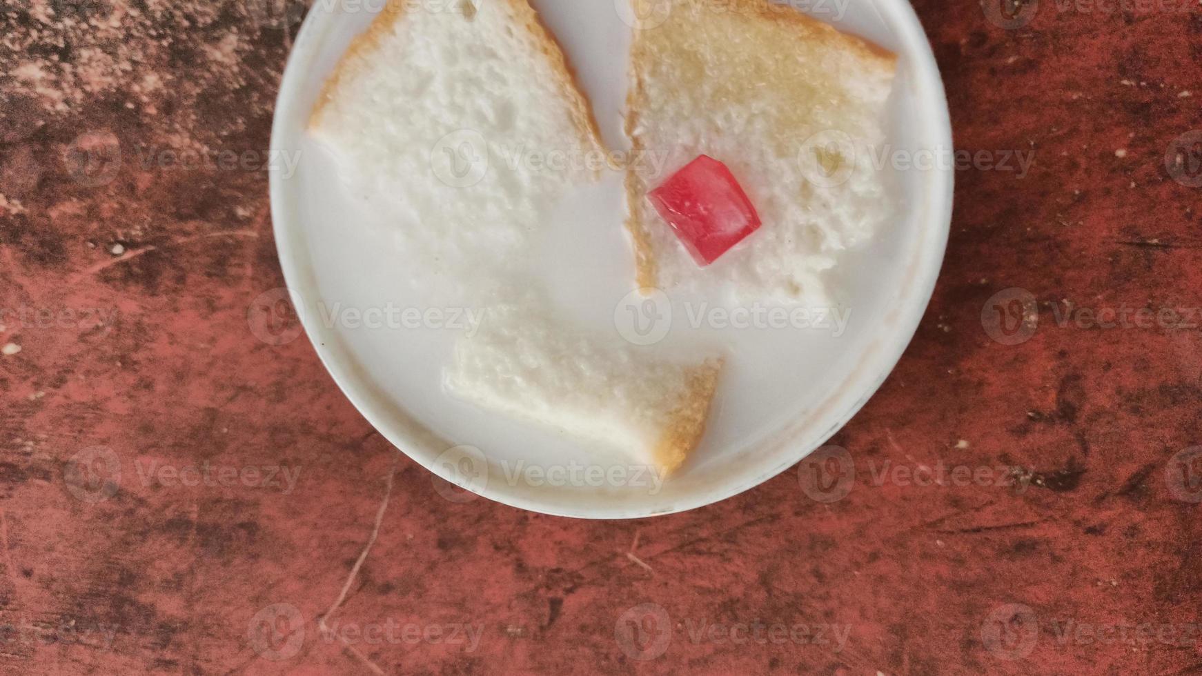 Wedang-Asle-Essen, serviert in einer Schüssel mit Milch, gemischt mit Klebreis und ein paar kleinen Scheiben Weißbrot foto