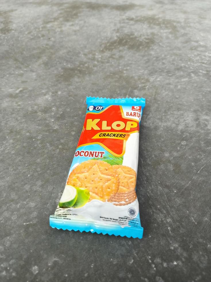sukoharjo - 8. juni 2022 - snack namens marke klop cracker, kokosgeschmack, zementbodenhintergrund, süßer keks mit kokosgeschmack foto