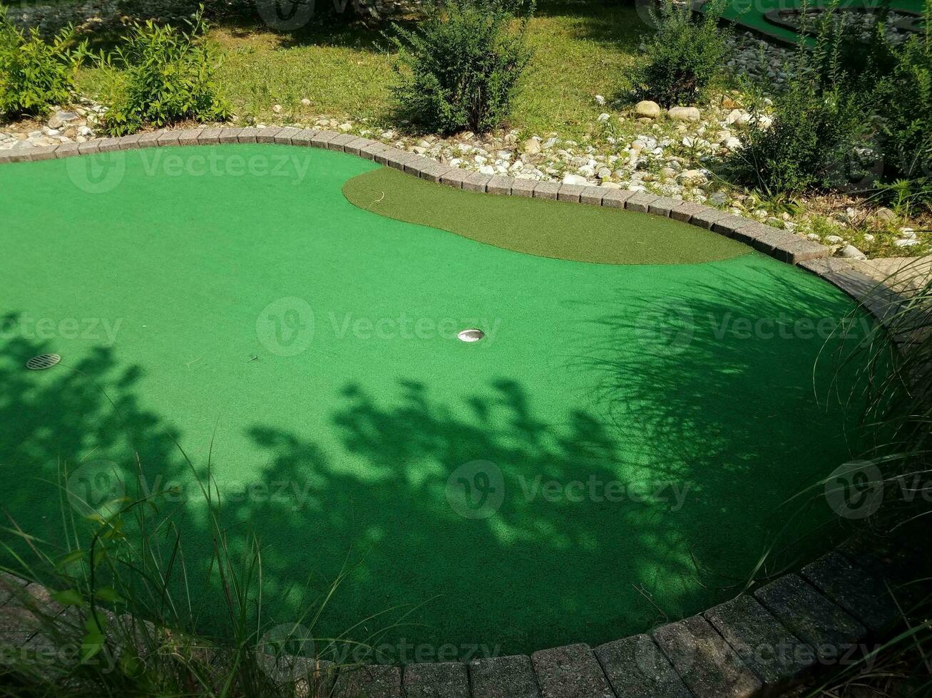 Loch auf Minigolfplatz mit grünem Kunstrasen foto