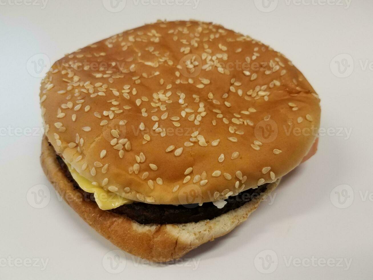 Hamburger mit Käse und Brötchen mit Samen auf weißem Hintergrund foto