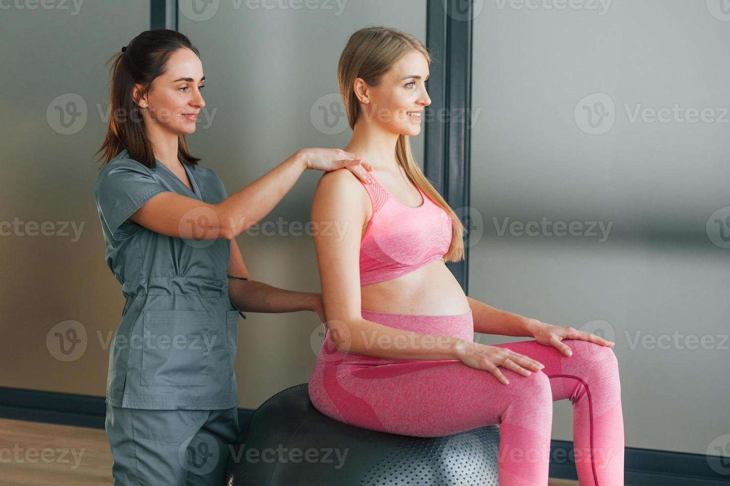 schwangere frau in rosa kleidung. im Gesundheitszentrum Hilfe vom Arzt bekommen foto
