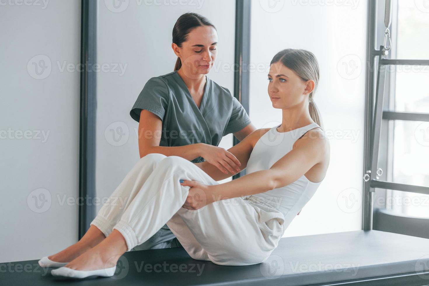 Bauchmuskeln machen. frau ist im gesundheitszentrum und bekommt hilfe vom arzt foto