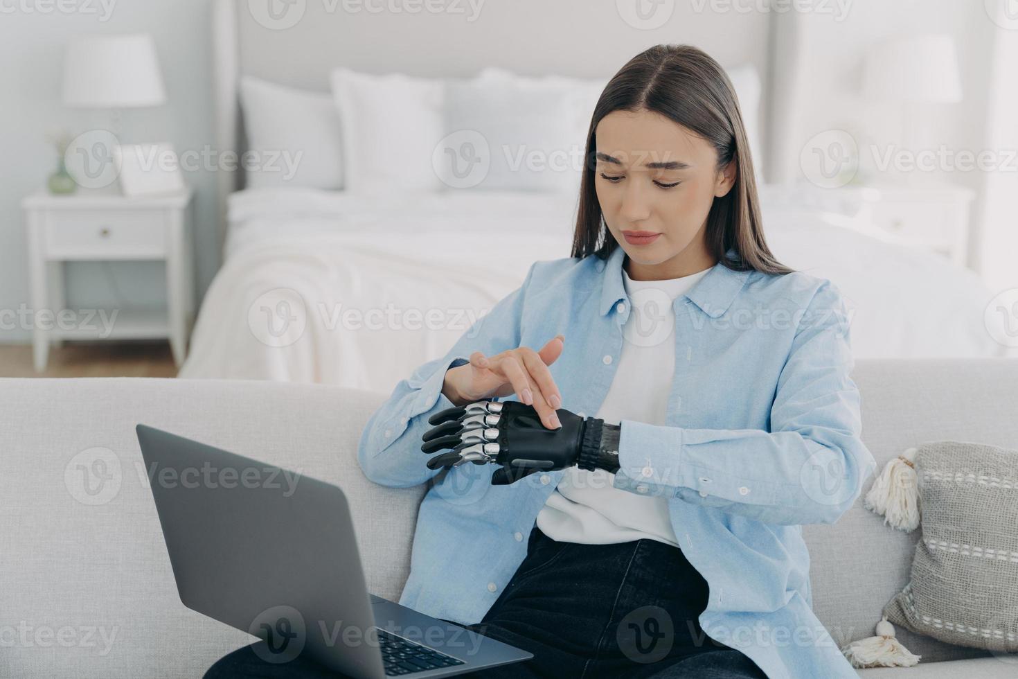 Mädchen vor PC stellt bionische Prothese ein. junge europäerin passt künstliche hand an. foto