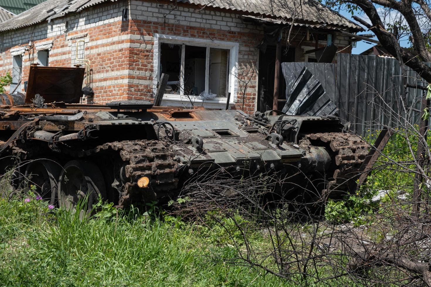 charkiw, ukraine - 04. mai 2022. ein verbrannter russischer panzer in der nähe eines wohngebäudes. krieg in der ukraine 2022. russische raketen in der landschaft von charkiw ukraine. russischer angriff auf die ukraine. foto