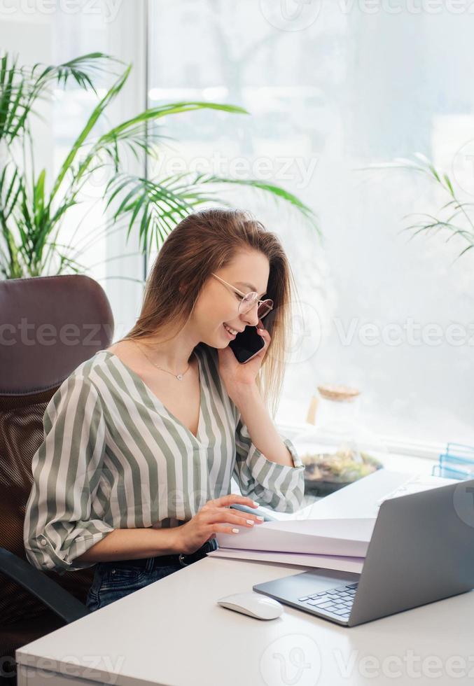 junge Frau, die an einem Computer arbeitet foto